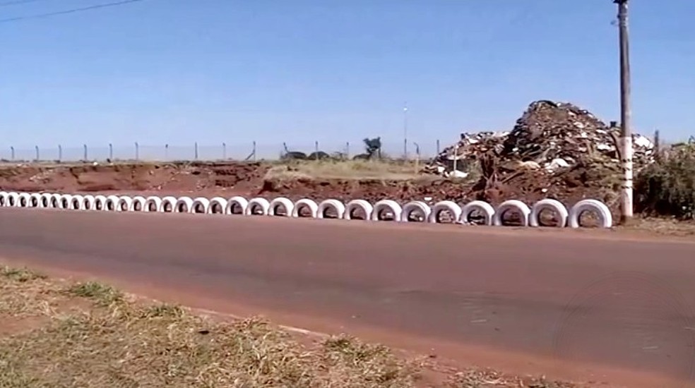 Local é destinado a descarte de material inservível, mas com horário e regras definidos; proteção com pneus tenta evitar descarte irregular — Foto: TV TEM/Reprodução
