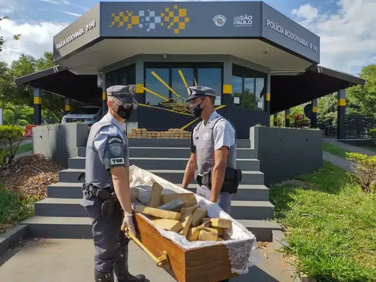 Tijolos de maconha foram escondidos dentro do caixão que estava no carro de funerária que era guinchado (Foto: Polícia Rodoviária / Divulgação)
