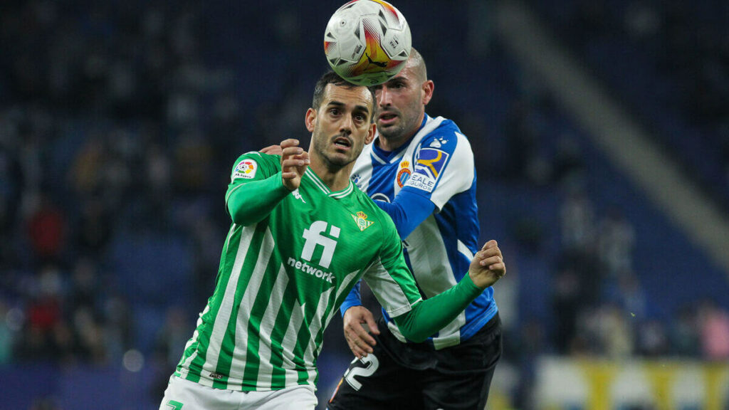 Verdadeiros jogadores Betis vs Espanyol tentando alcançar a bola.