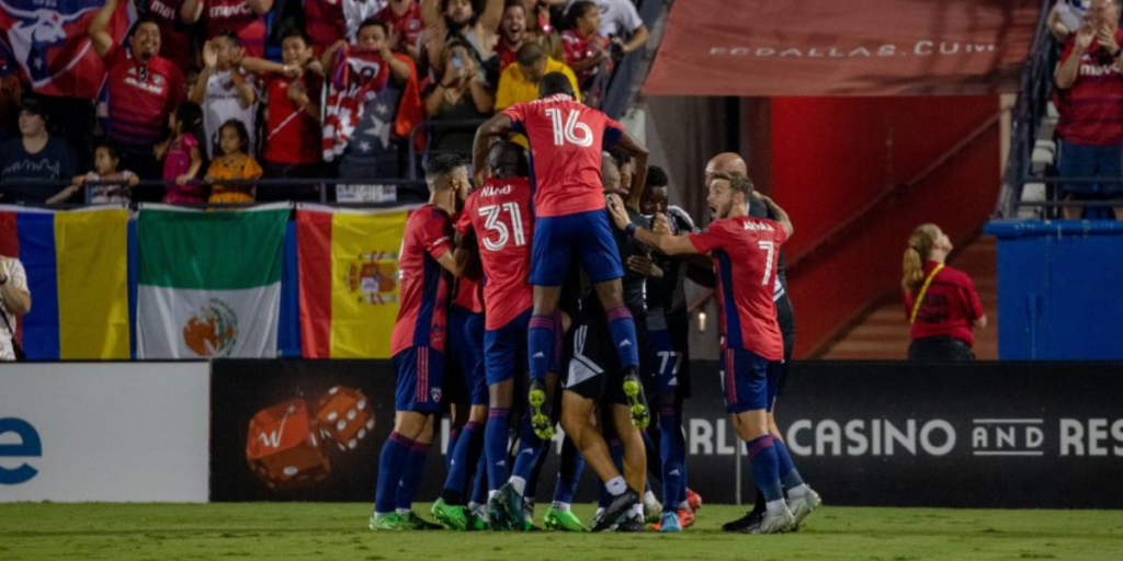Jesus Ferreira comemorando com seus companheiros de equipe após marcar dois gols.